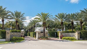 A gated entrance with palm trees, a stone wall, and a sign reading "Eans Edge."