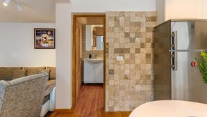 Eine moderne Küche mit einem Edelstahl-Kühlschrank, einer gefliesten Spritzschutzwand und Holzboden.