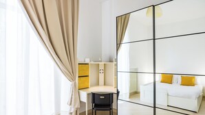 A modern room with a desk, chair, and a bed with yellow pillows. - Residenza Diaz by Wonderful Italy (Naples)