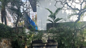 A swimming pool with a tiled floor, surrounded by potted plants and a stone wall. - Chic 2-bedroom condo with WiFi, fitness room and Pool in vibrant Quezon City (Quezon City)