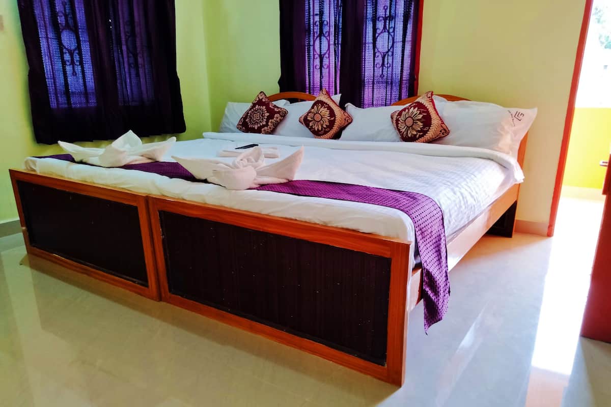 A bed with a wooden frame, white bedding, and decorative pillows.