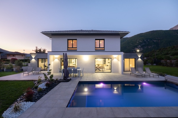 Maison au couché du soleil avec éclairage extérieur et piscine