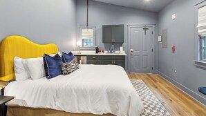 Un dormitorio con cama, mesita de noche y ventana con persianas.