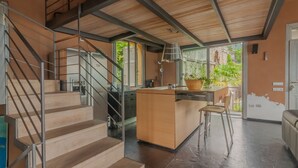 Una cucina moderna con isola centrale, una scala e vista su spazi verdi esterni.