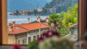Una cittadina costiera con edifici lungo la riva, una torre imponente e vegetazione rigogliosa.