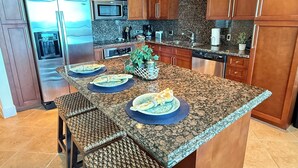 A modern kitchen with granite countertops, stainless steel appliances, and wooden cabinets.