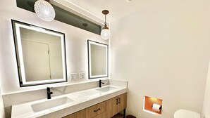 A modern bathroom with two vanity mirrors, a toilet, and a sink. - Tranquil 3-bedroom house in Palm Springs with WiFi and AC (Palm Springs)