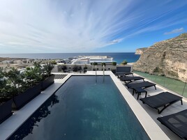 Una piscina al aire libre de temporada, sombrillas