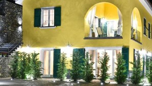 A yellow building with green shutters, a balcony, and a stone wall. - VESPA SPRINT APARTMENT Amazing Nature 10' to the beach +PVT Park in City Centre! (Roverano Basso)