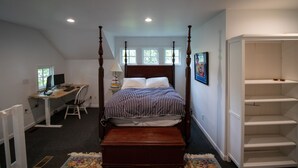 A bedroom with a four-poster bed, a desk with a computer, and a chair. - Gorgeous Historic Carriage House with fine furnishings and modern amenities (Atlanta)