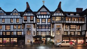 A traditional Tudor-style building with a prominent entrance and multiple windows. - Zedwell Capsule Hotel, Piccadilly Circus (London)