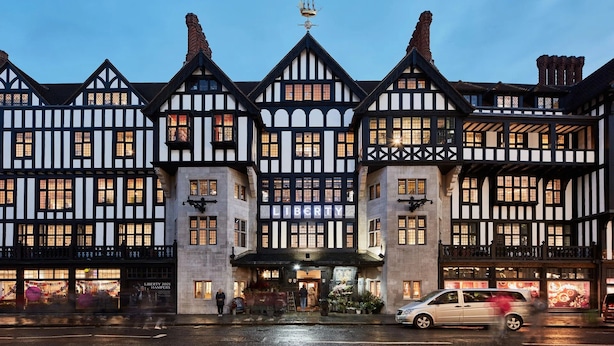 Un edificio de estilo Tudor tradicional, con una entrada destacada y numerosas ventanas.