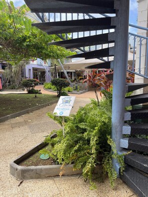 Relax under the shade of a pergola amidst lush greenery and modern architecture.