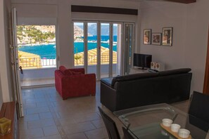 Relax in this stylish living room with a balcony offering breathtaking views of the sea and mountains.