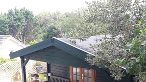 Un patio techado con un banco de madera y una pequeña zona de estar.