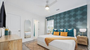 Ein Schlafzimmer mit Bett, Nachttisch, Deckenventilator.