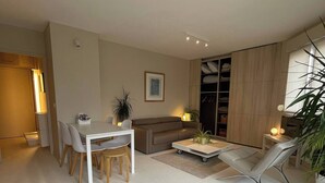 A modern living room with a dining area, a sofa, a coffee table, and a plant. - 2 rooms old lille, superb terrace, parking (Lille)