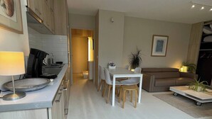 A modern kitchen with a dining area, a sofa, and a coffee table. - 2 rooms old lille, superb terrace, parking (Lille)
