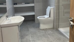 Ein modernes Badezimmer mit einem Oberlicht, einer Dusche und einer Toilette.