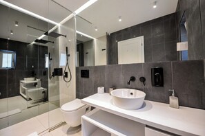 A modern bathroom with a glass-enclosed shower, a white sink, and a toilet. - Blue Moon - One Bedroom - Romana Square (Bucharest)