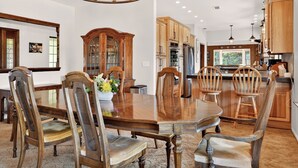 A spacious kitchen with wooden cabinets, a central island, and a chandelier. - Amazing Views, Secluded property, 2025 Remodeled, Near Yosemite & Amenities (Oakhurst)