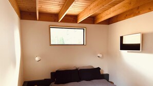 Une chambre à coucher avec un lit, une petite table et une fenêtre.