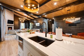A modern kitchen with a large island, built-in appliances, and a fireplace.