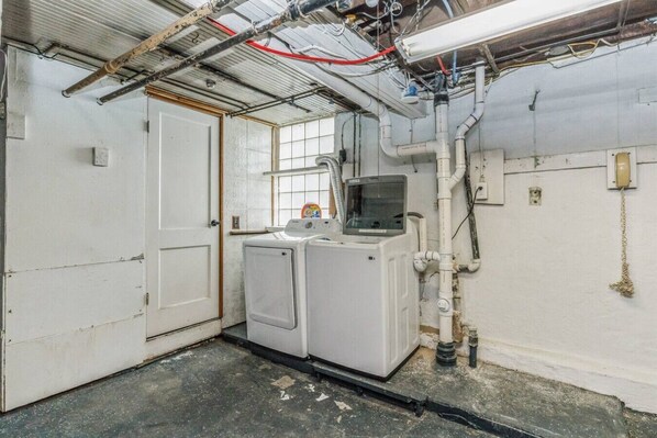 A laundry room with a washing machine, dryer, and a small window. - Forest Hills 3BR Home w/ Parking + Keypad Entry (Pittsburgh)