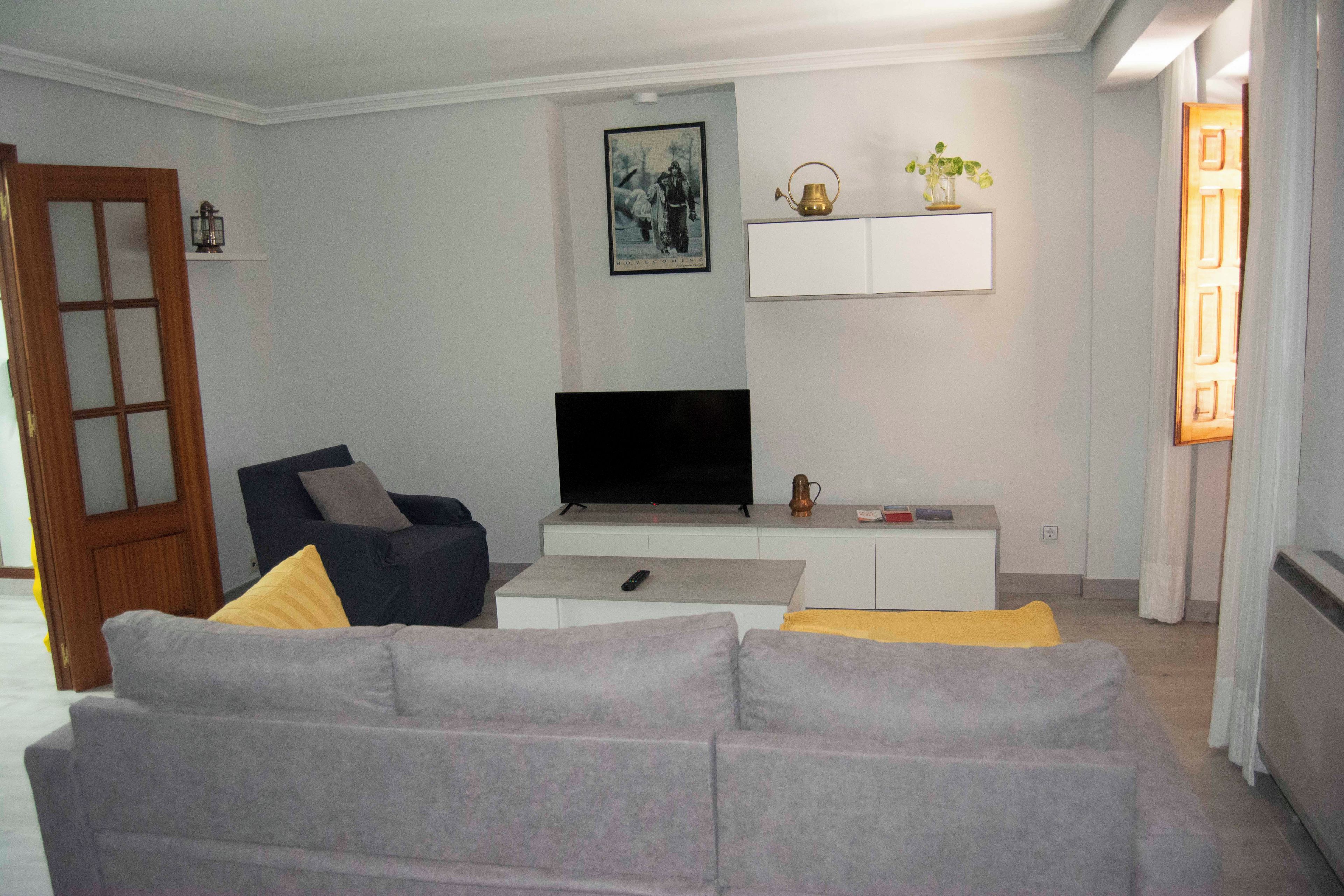 A living room with a sofa, a television, and a cabinet.