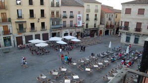 Un área de estar al aire libre con numerosas mesas y sillas, rodeada de edificios con diversos comercios.