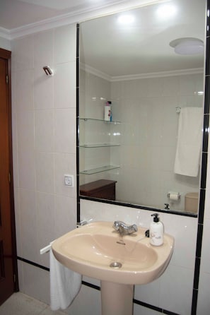A bathroom with a sink, mirror, and glass shelves. - The Vettones. Right in the heart of Ciudad Rodrigo. (Ciudad Rodrigo)