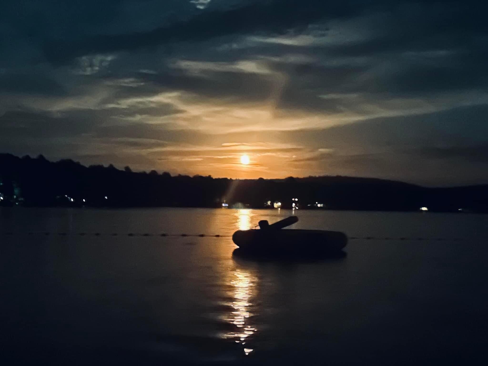 Una embarcación sobre aguas tranquilas reflejando el atardecer.