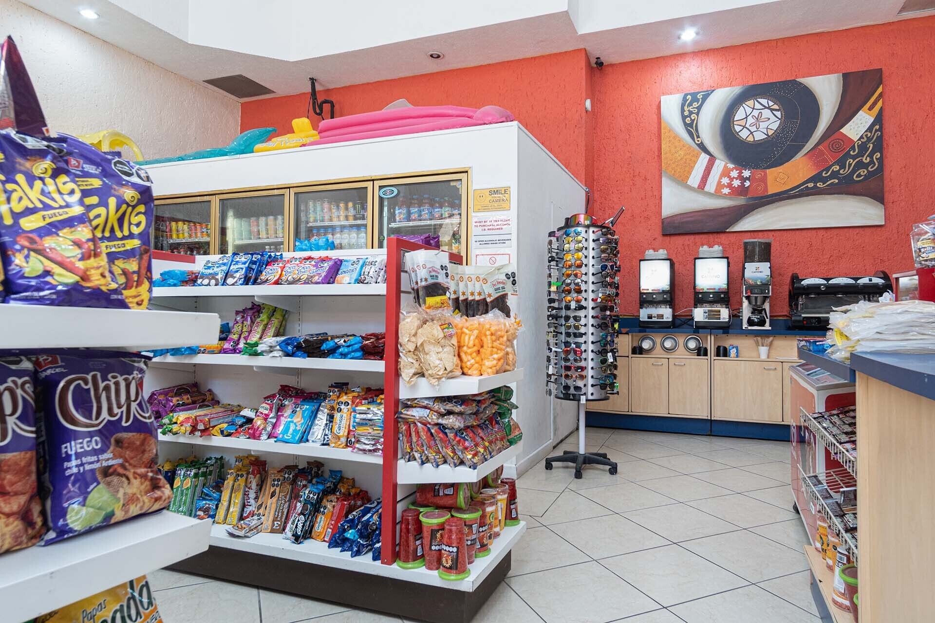 Een kiosk met een ruime keuze aan chips en snacks, een koffieapparaat en een camera.