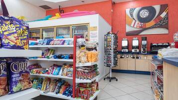 Een kiosk met een ruime keuze aan chips en snacks, een koffieapparaat en een camera.