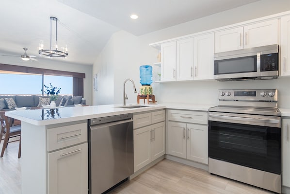 A modern kitchen with white cabinetry, a built-in dishwasher, a double oven, and a microwave. - Sonoran Sun II (Puerto Peñasco)