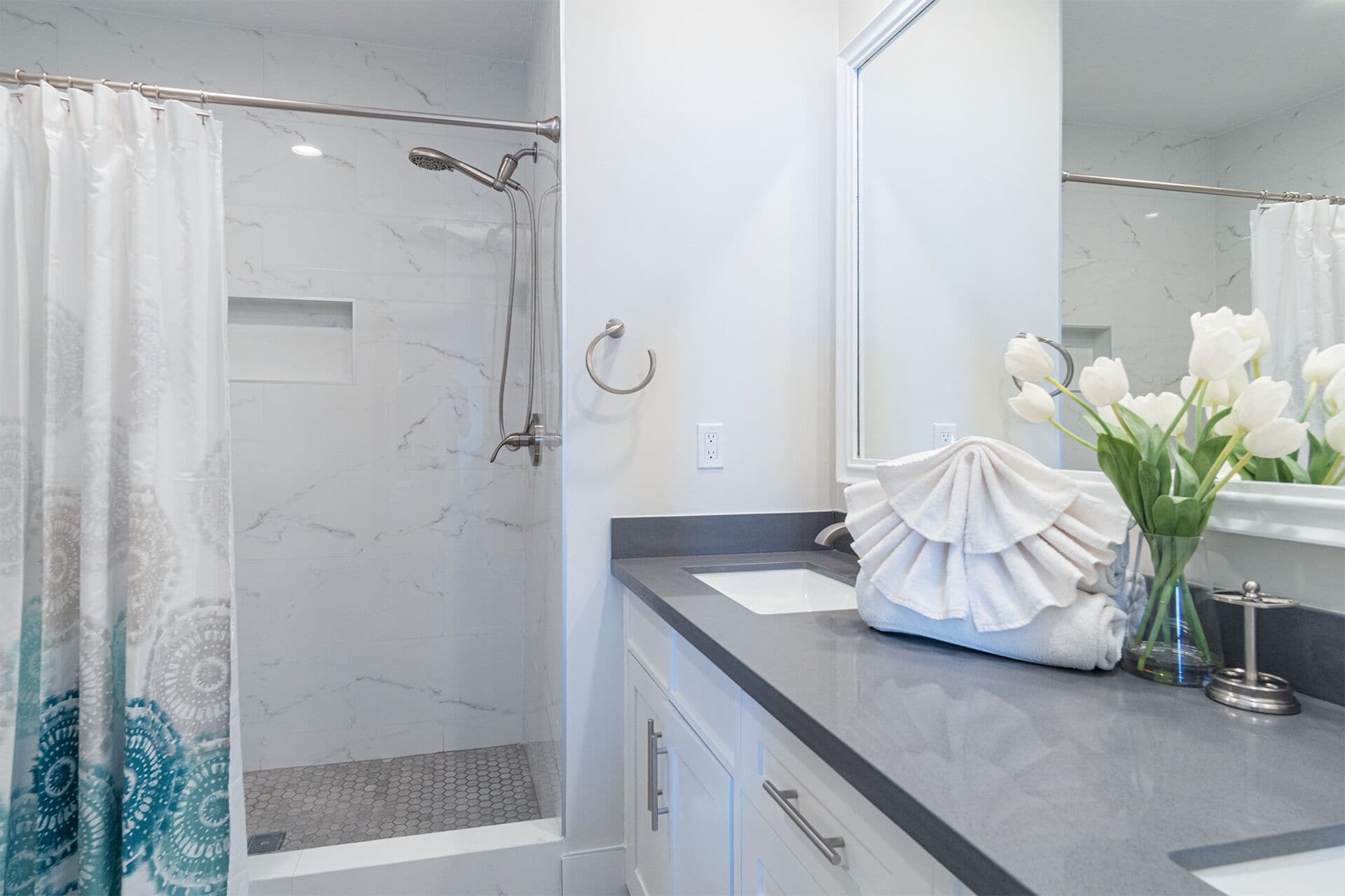 Un baño moderno con ducha, lavabo y espejo.