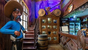 Un bar avec des meubles en bois, une statue et un escalier.