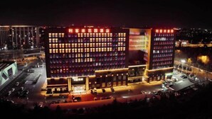 A multi-story hotel with a modern design, featuring a prominent entrance and a parking area in front. - Qingdao Likelai Garden Hotel (Chengyang Zhengyang Middle Road Metro Station) (Qingdao)