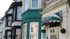 Ein traditionelles Gebäude mit grüner Fassade, einem Schild für das Franklin Hotel und einer Statue eines Kindes.