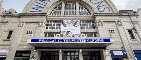 A large, historic building with a prominent arched entrance labeled "Winter Gardens."