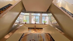 A modern interior with a central staircase, large windows, and potted plants. - Gaocheng Dushi 118 Chain Hotel (Shijiazhuang)