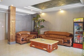 A lobby with a sectional sofa, a wooden coffee table, and a vending machine. - Gaocheng Dushi 118 Chain Hotel (Shijiazhuang)