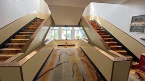 A modern interior with two symmetrical staircases leading to a central area with large windows. - Gaocheng Dushi 118 Chain Hotel (Shijiazhuang)