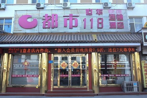 Un hotel con un letrero llamativo y decoraciones chinas tradicionales.