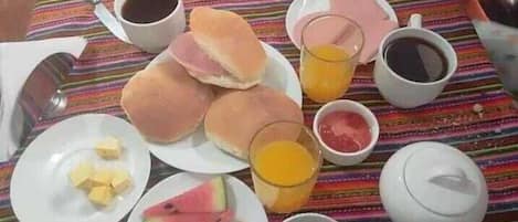 A table with food items including sandwiches, watermelon, and beverages.