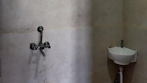Un baño con ducha, lavabo e inodoro.