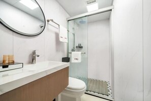 A modern bathroom with a glass shower enclosure, a white toilet, and a wooden vanity. - Shanghai Red Carp Business Hotel (Zhujiajiao Scenic Area Ancient Town) (Shanghai)