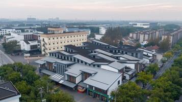 A commercial area with multiple buildings, including a large white building with a flat roof and several smaller structures with sloped roofs.