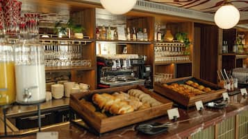 Un espace bar avec des étagères remplies de bouteilles, de verres et une machine à café.