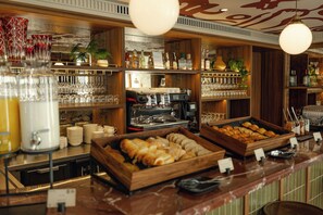 A bar area with shelves of bottles, glasses, and a coffee machine. - SALVIA Paris (Paris)